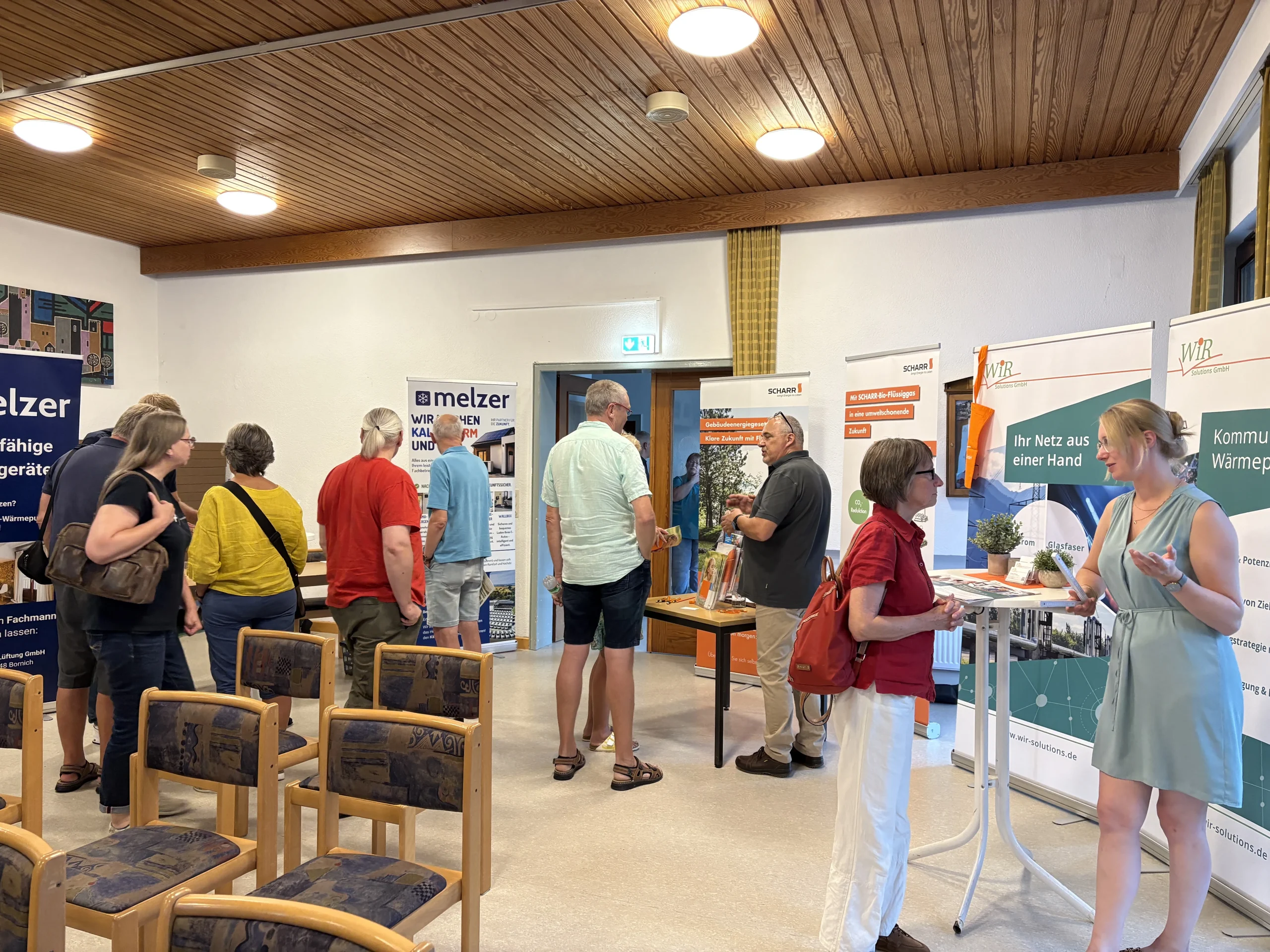 Besucherinnen und Besucher informieren sich an verschiedenen Ständen rund um die kommunale Wärmeplanung und Energieversorgung in Heidenrod.