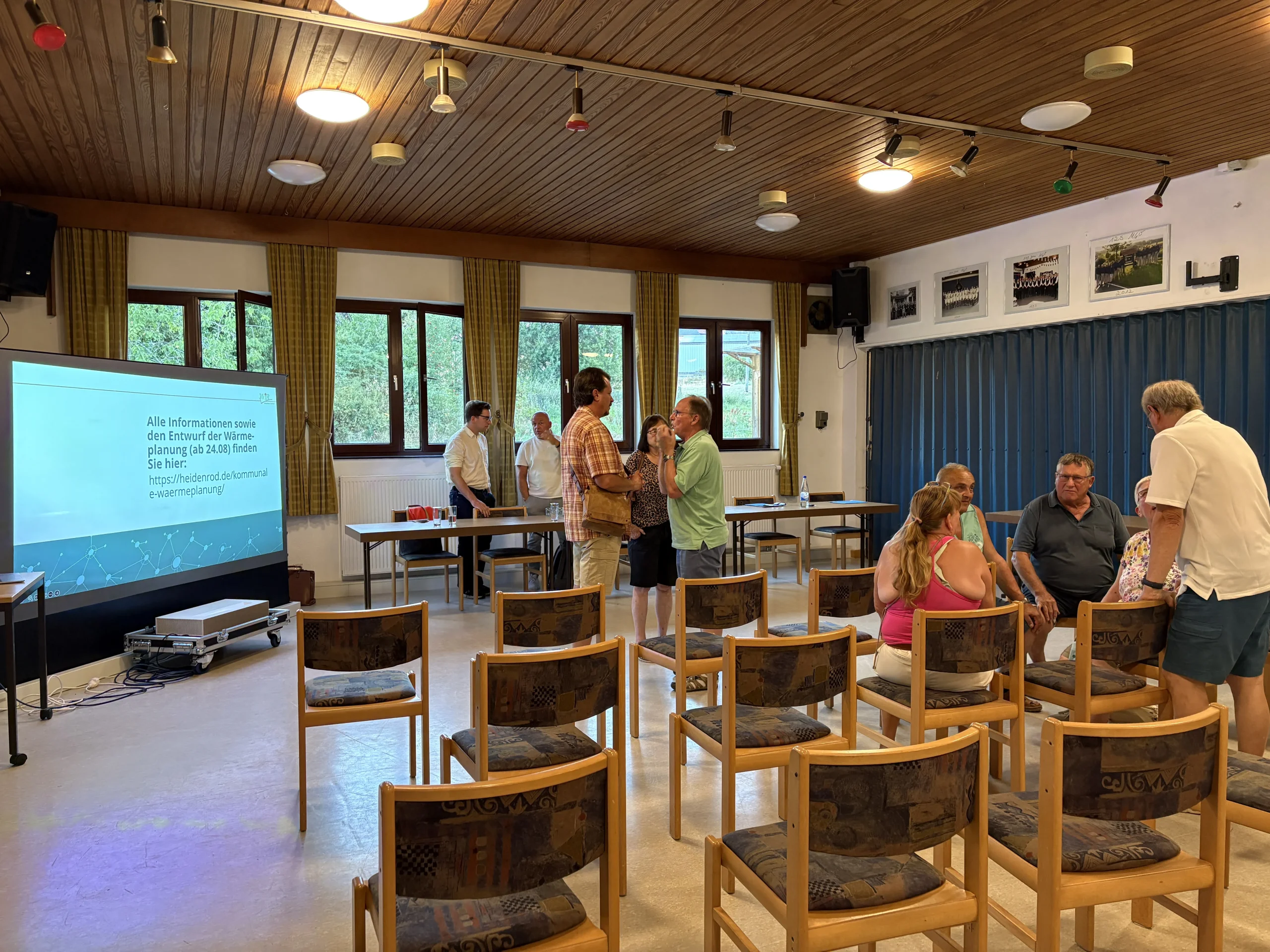 Bürgerinnen und Bürger im Gespräch nach einer Informationsveranstaltung zur kommunalen Wärmeplanung in einem Heidenroder Bürgerhaus.